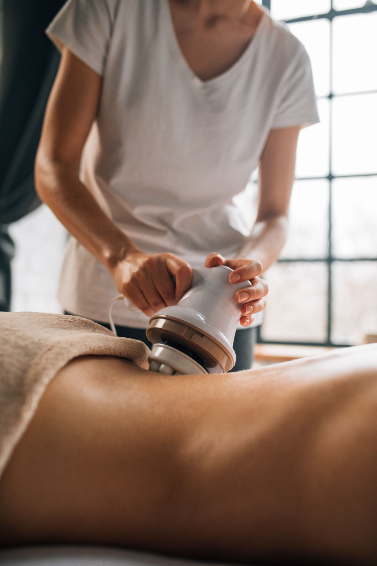 Non-invasive body contouring treatment being applied in warm studio light at the Mountain Rejuvenation Center