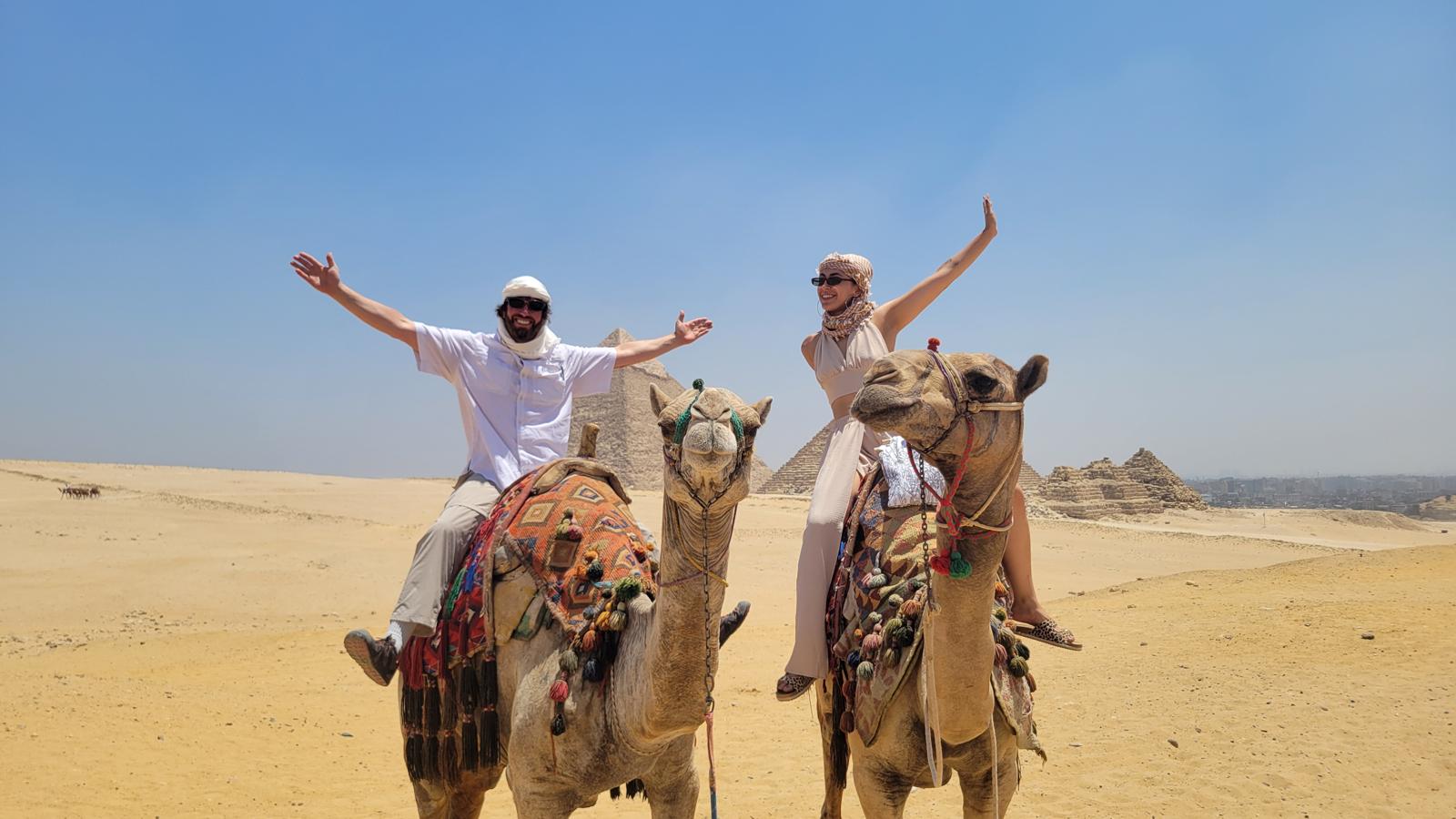 Riding camels together at the pyramids of Giza
