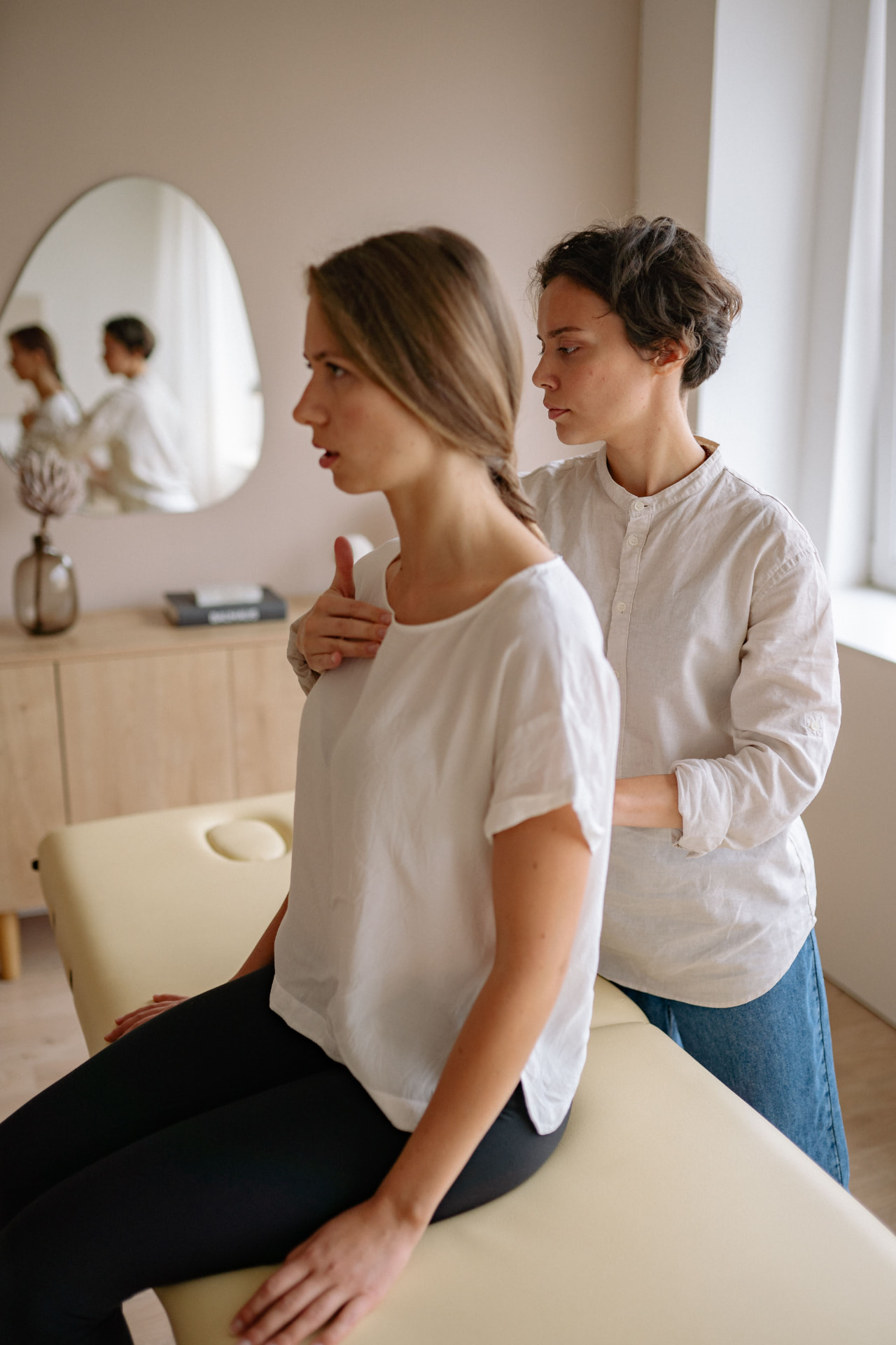 Practitioner guiding a client through a somatic posture and spinal alignment assessment